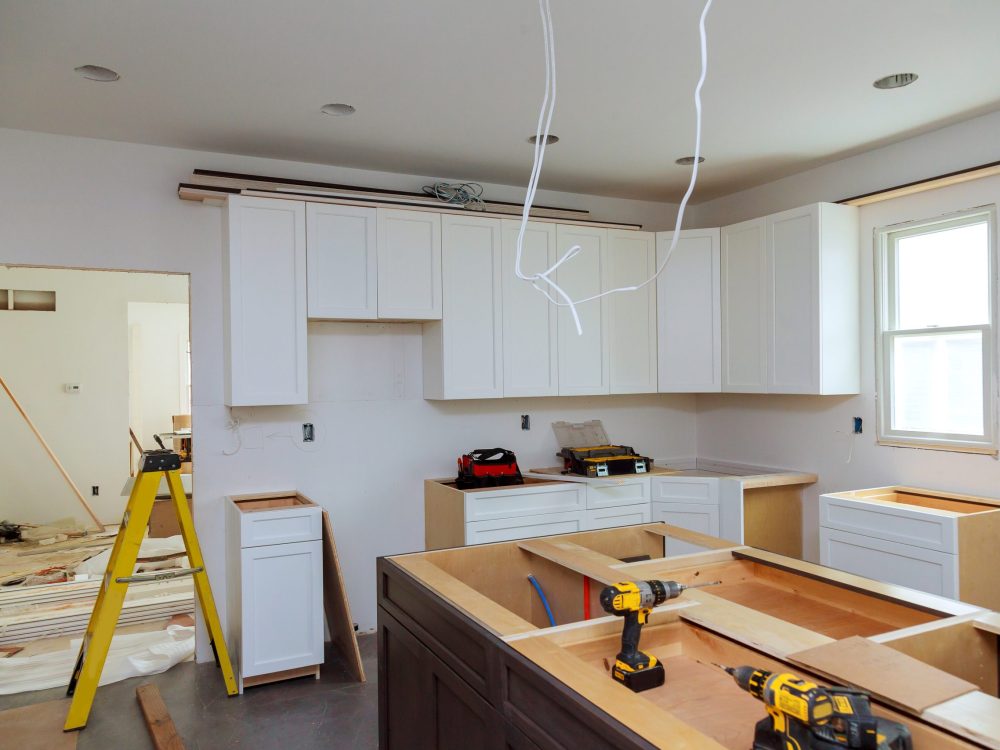 In a set of furniture under construction, white kitchen wooden cabinets were installed with a home improvement view